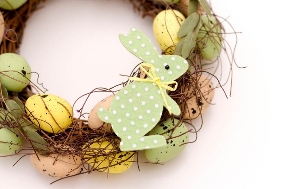 Corona de pascua con huevos de colores y conejo en tela verde con lunares.