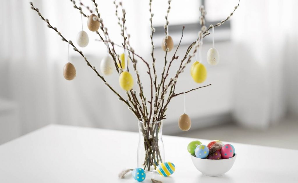 Albert de Pascua con ramas de árboles, huevos de colores y flores.