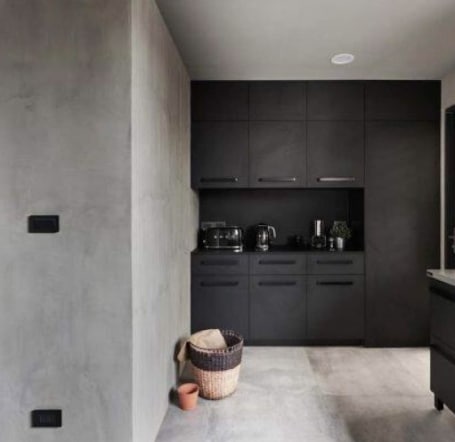 Una cocina con una pared de efecto cemento.
