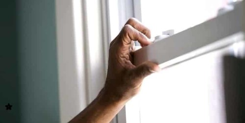 Imagen que muestra a una persona cerrando la ventana de su casa